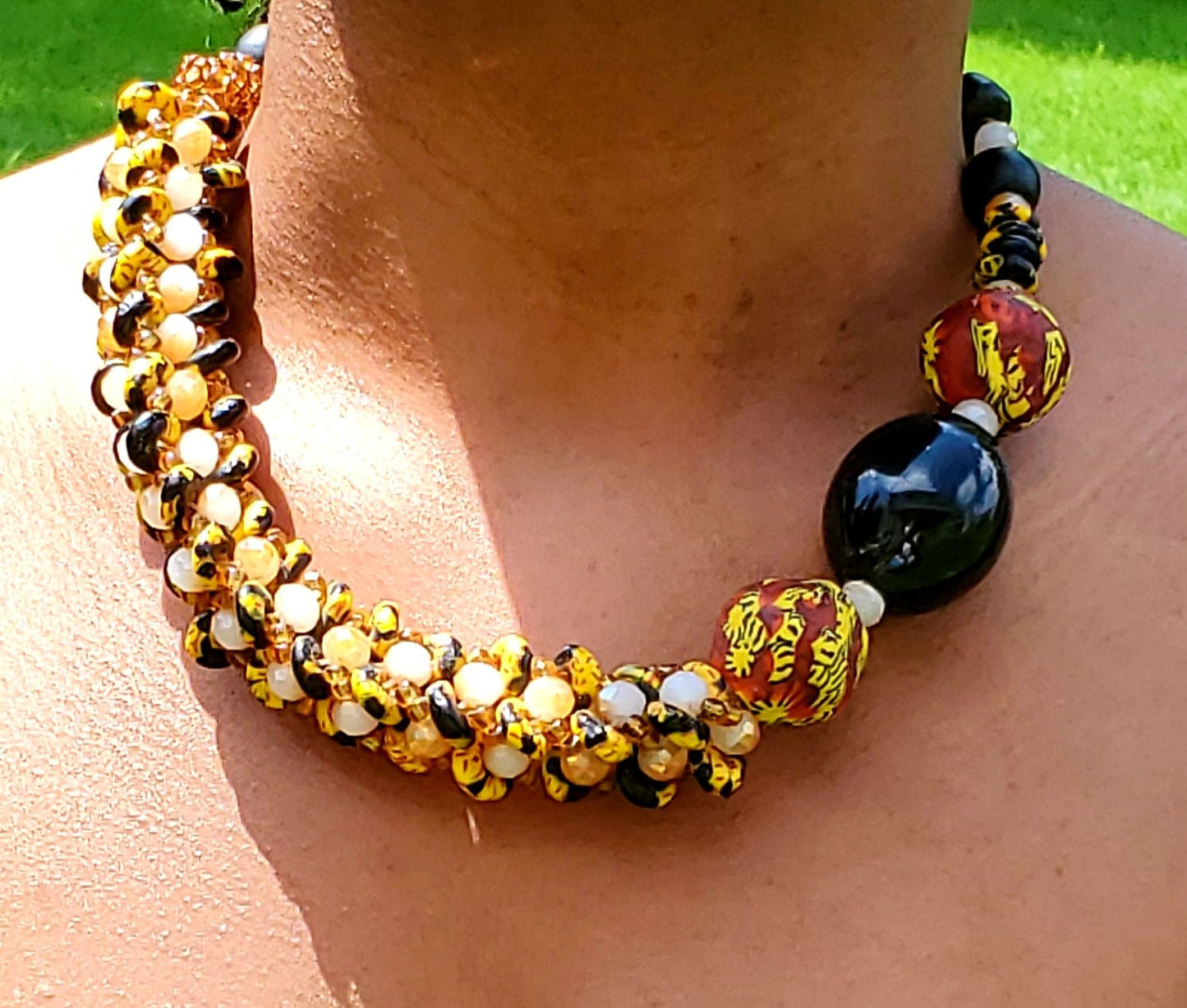 Traditional Ghana yellow glass beaded necklace, with three large colored side beads, front view, worn on neck